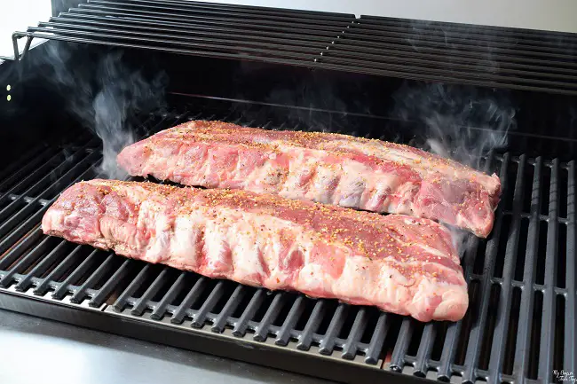 baby back ribs smoking on grill