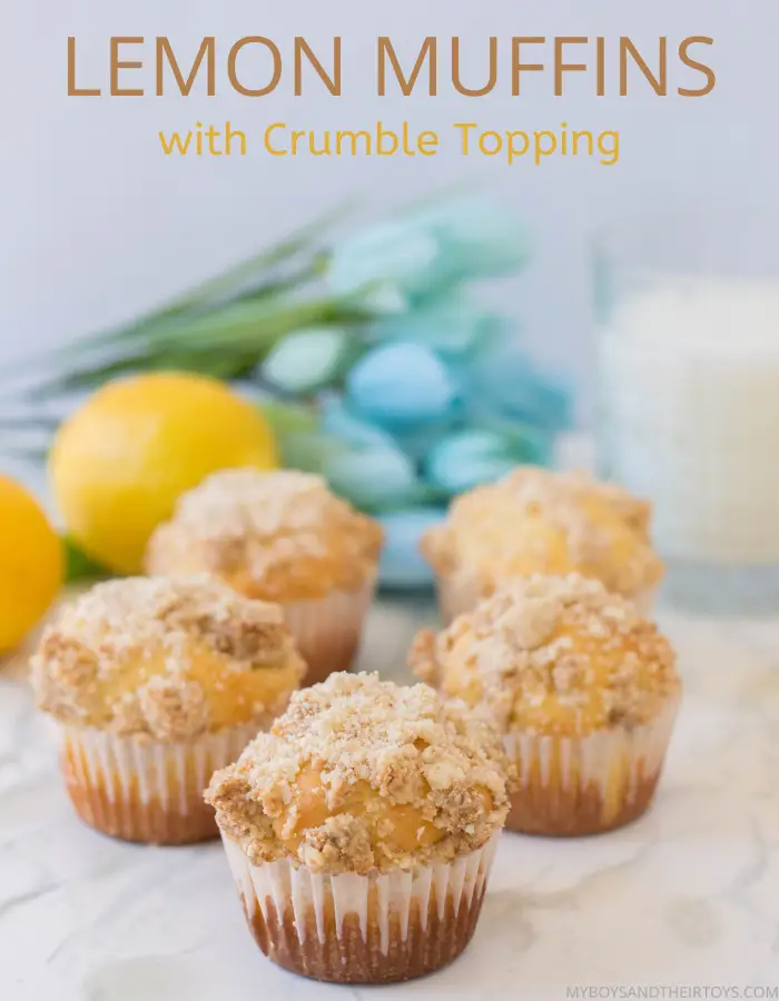 lemon muffins with crumble topping on counter with lemons and blue flowers
