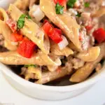 beef pasta tomato onions penne in white bowl