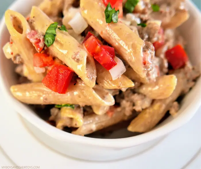 beef pasta tomato onions penne in white bowl